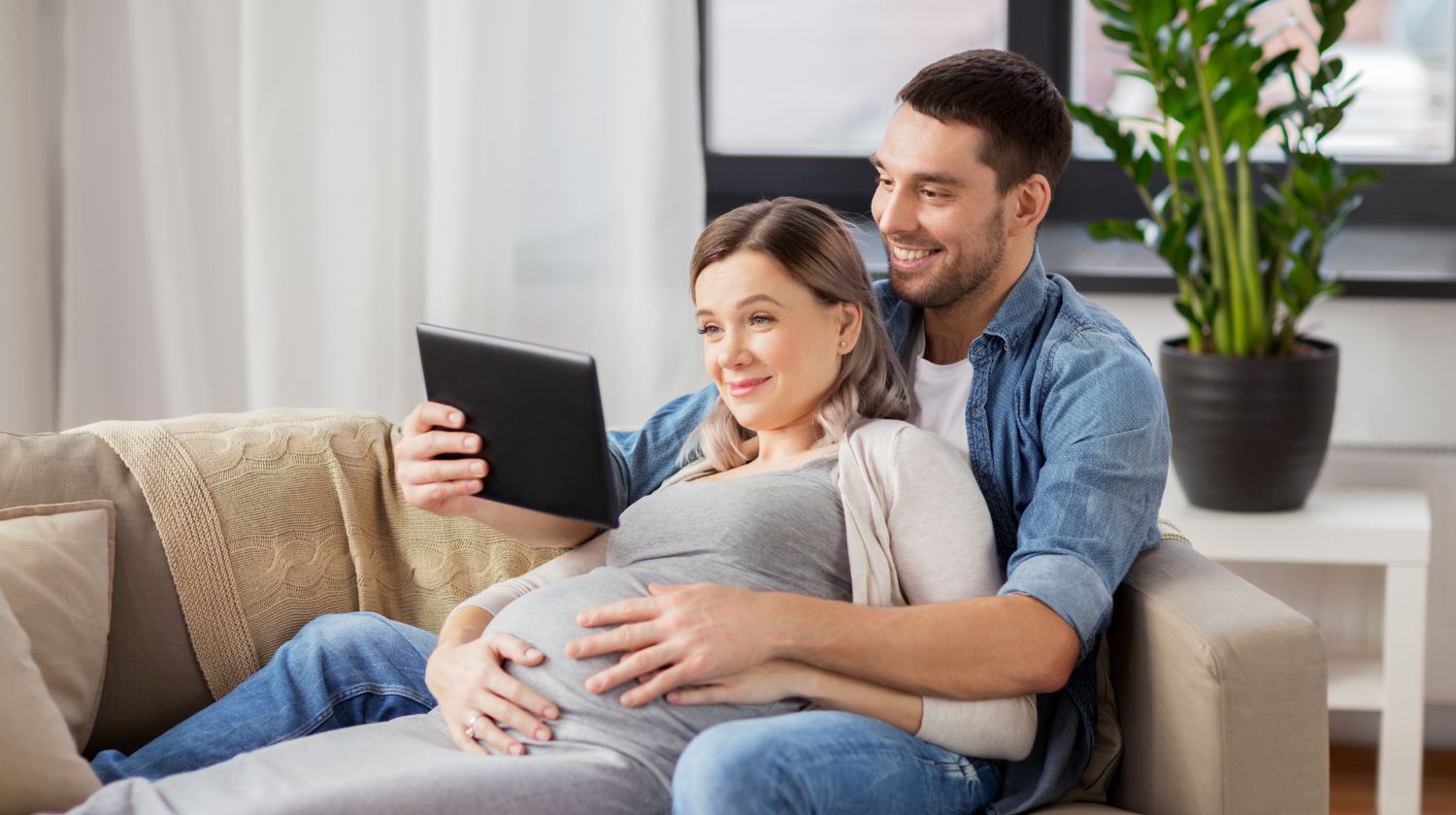 trudna žena sa partnerom čita sa tableta