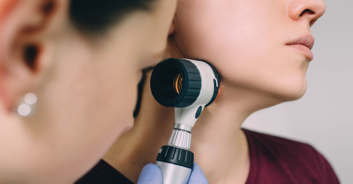 dermatolog sa dermatoskopom pregleda ženu
