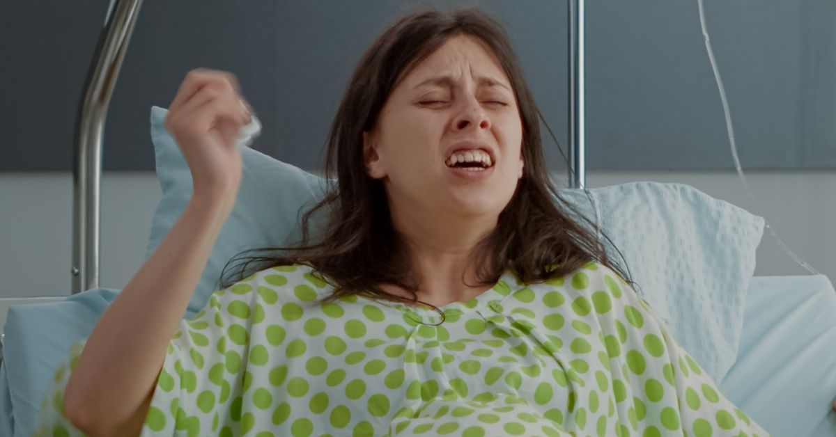 Žena u zelenoj spavaćici se porađa