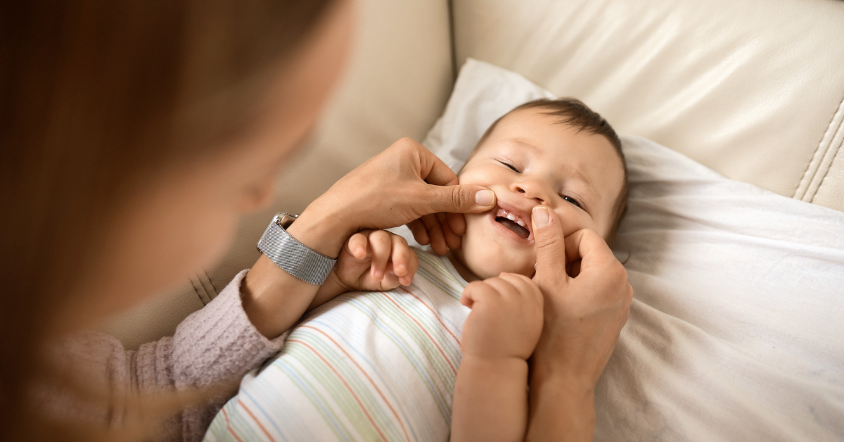 Mama proverava zubiće bebi