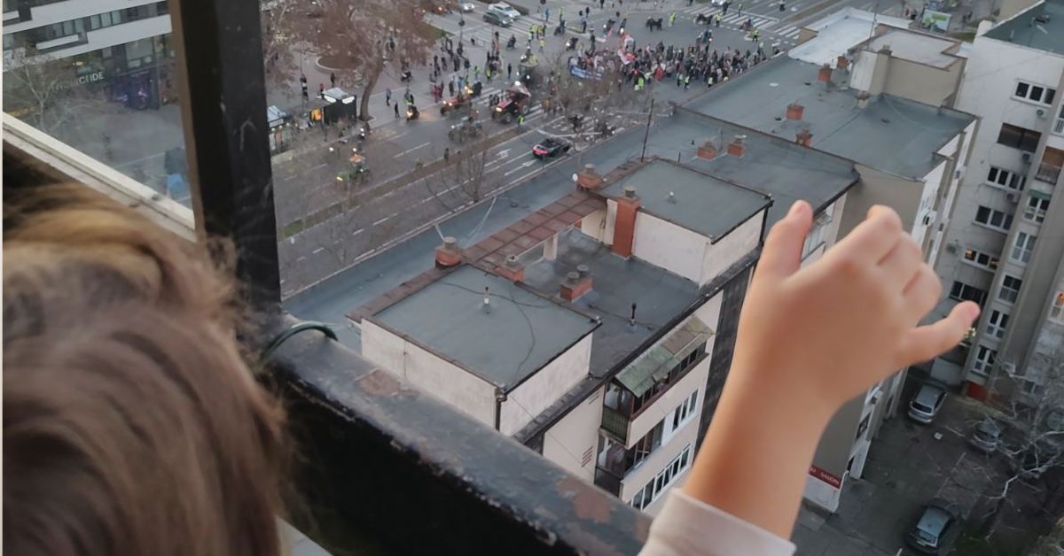 Dete maše demonstrantima sa terase