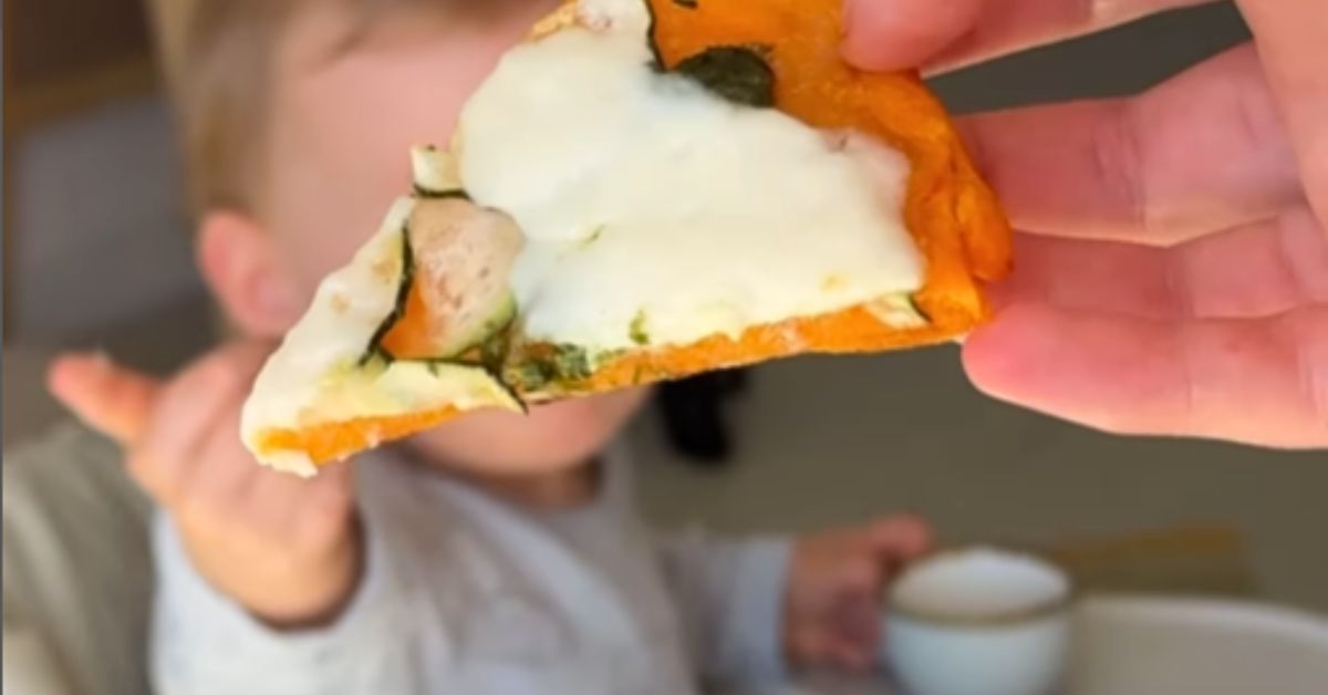 Parče pice iza beba koja pruža ruku