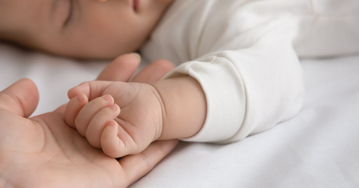Mama drži ruku bebe