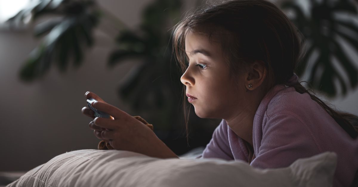 Devojčica gleda u mobilni telefon