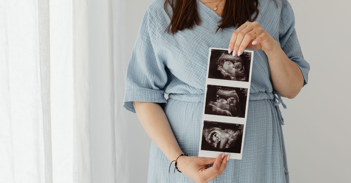 Žena drži uz snimak bebe u stomaku